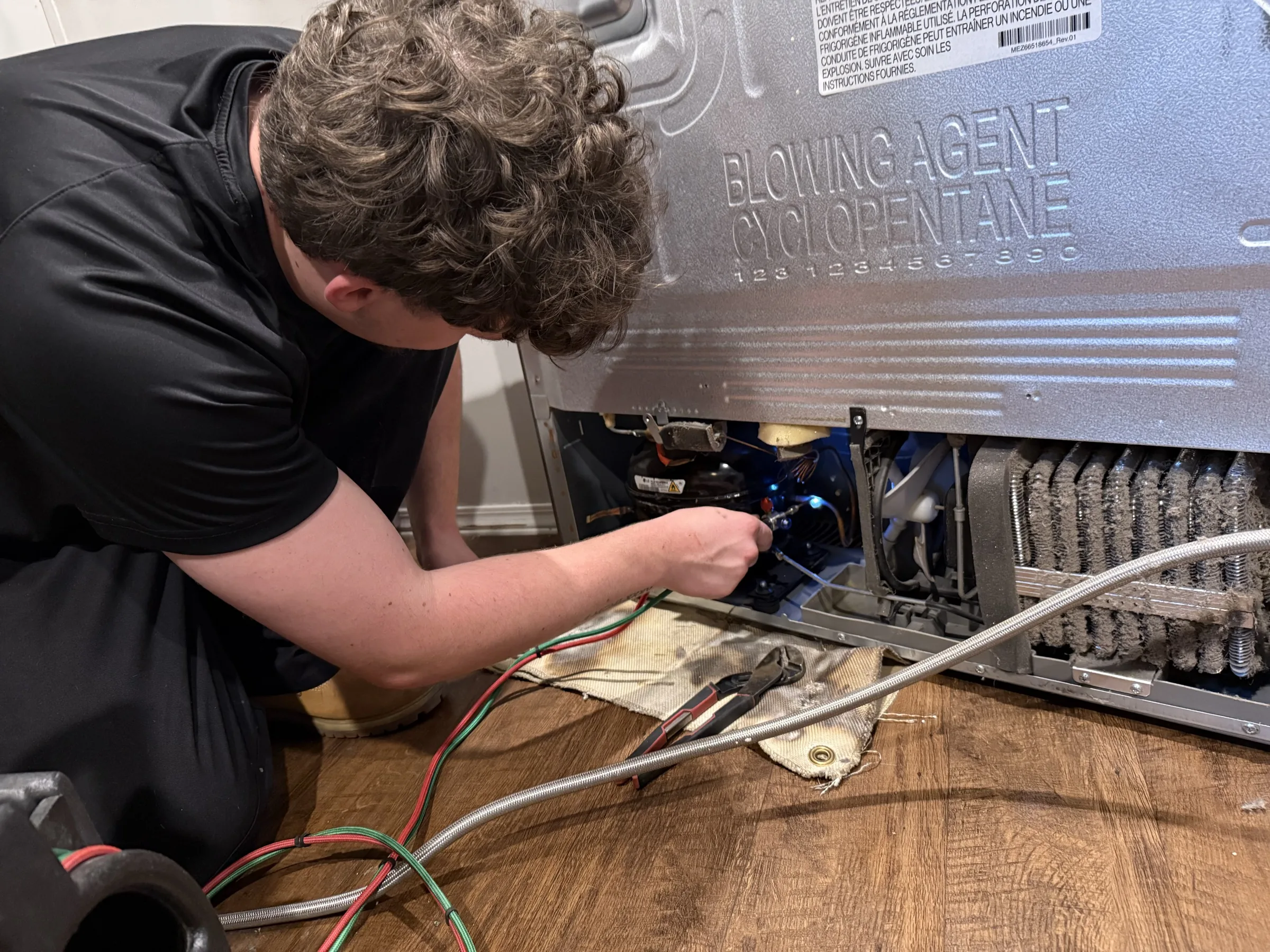 Technician performing refrigerator service work